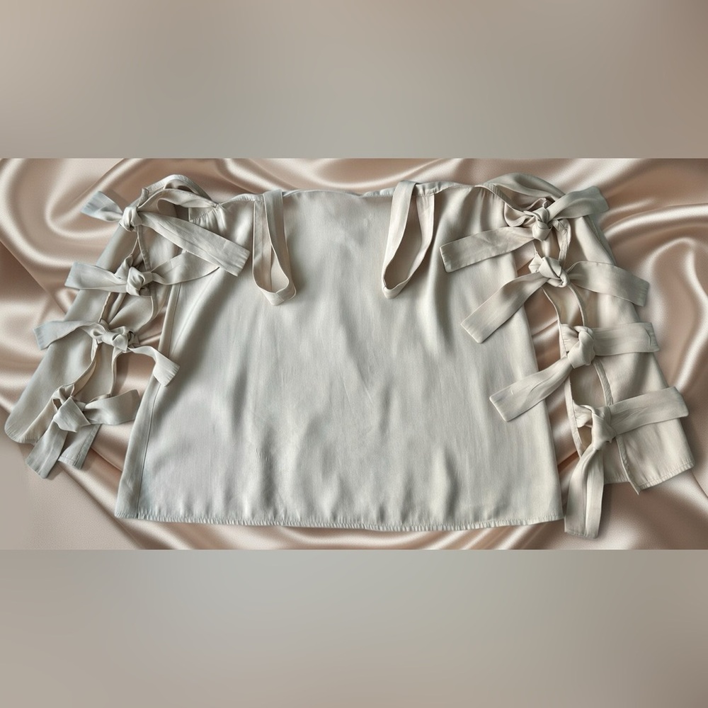 Women's elegant top multiple bow-tie details on the sleeves. Size S.